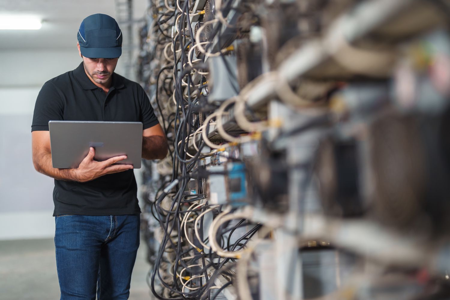 A man looks at a laptop in a crypto mine. 