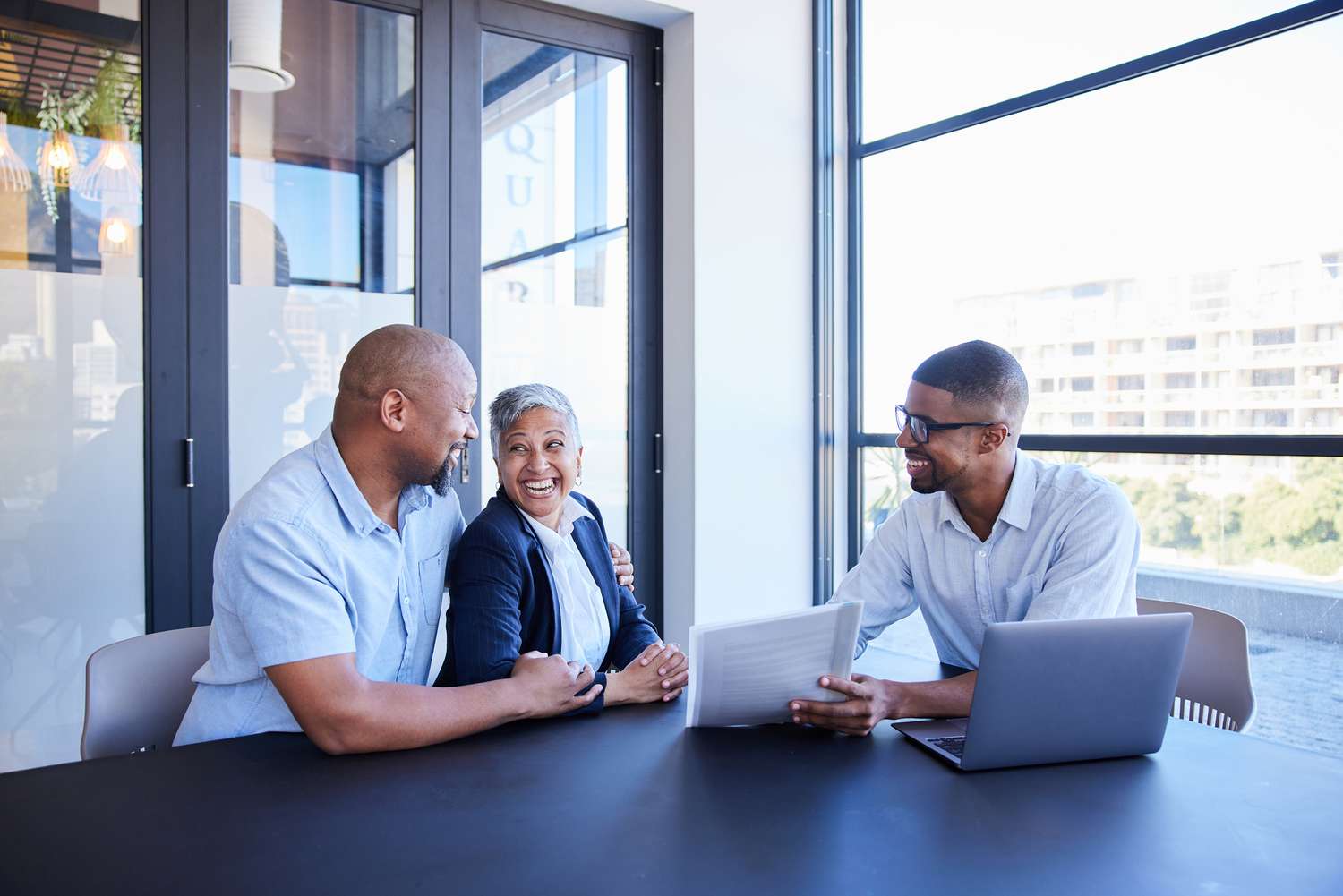 Mature couple smiling during a meeting with their financial advisor about CD rates