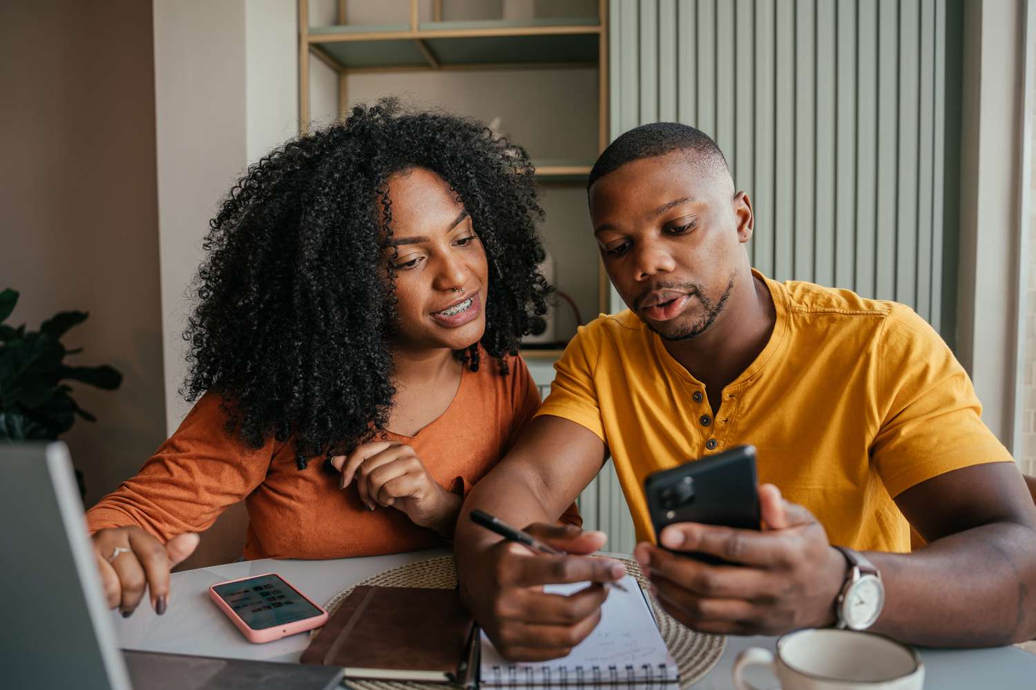 Young couple sitting at home and looking together at online mortgage rates and calculations
