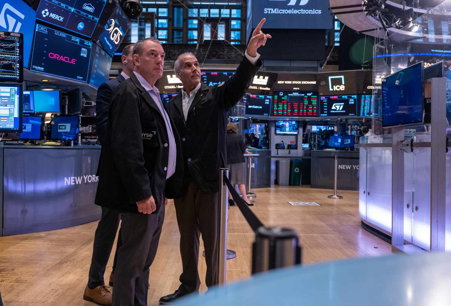 Traders on the floor of an Exchange looking up at a screen