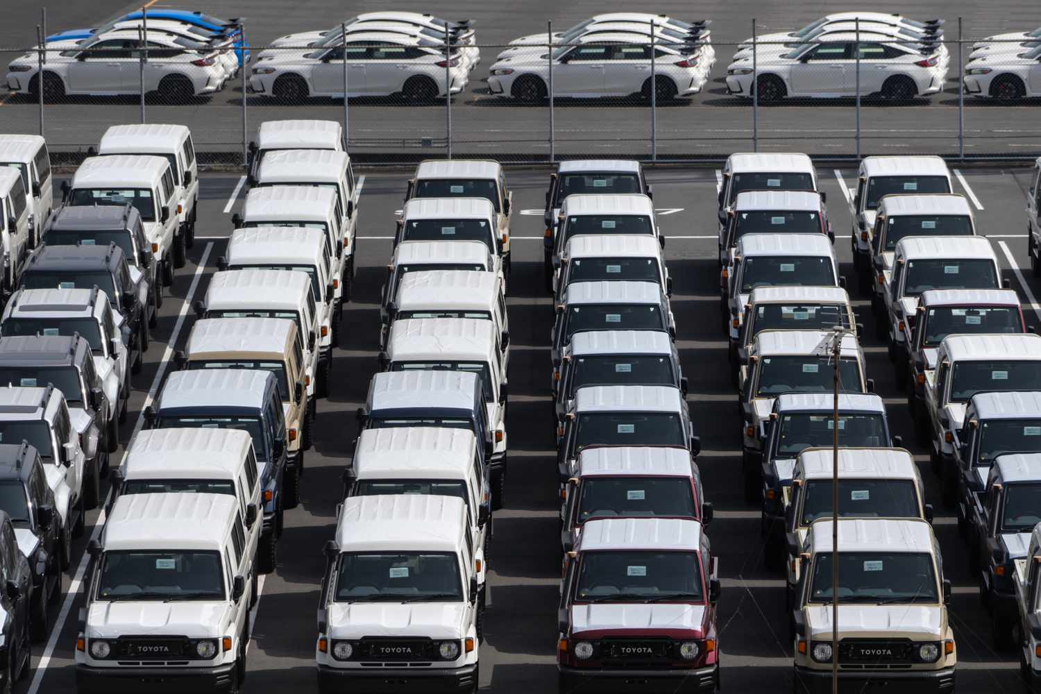 Toyota trucks awaiting shipment are parked at a port on March 27, 2025 in Yokohama, Japan