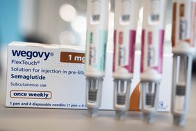 Four injector pens of the weight-loss drug Wegovy standing upright in front of a white box of the drug