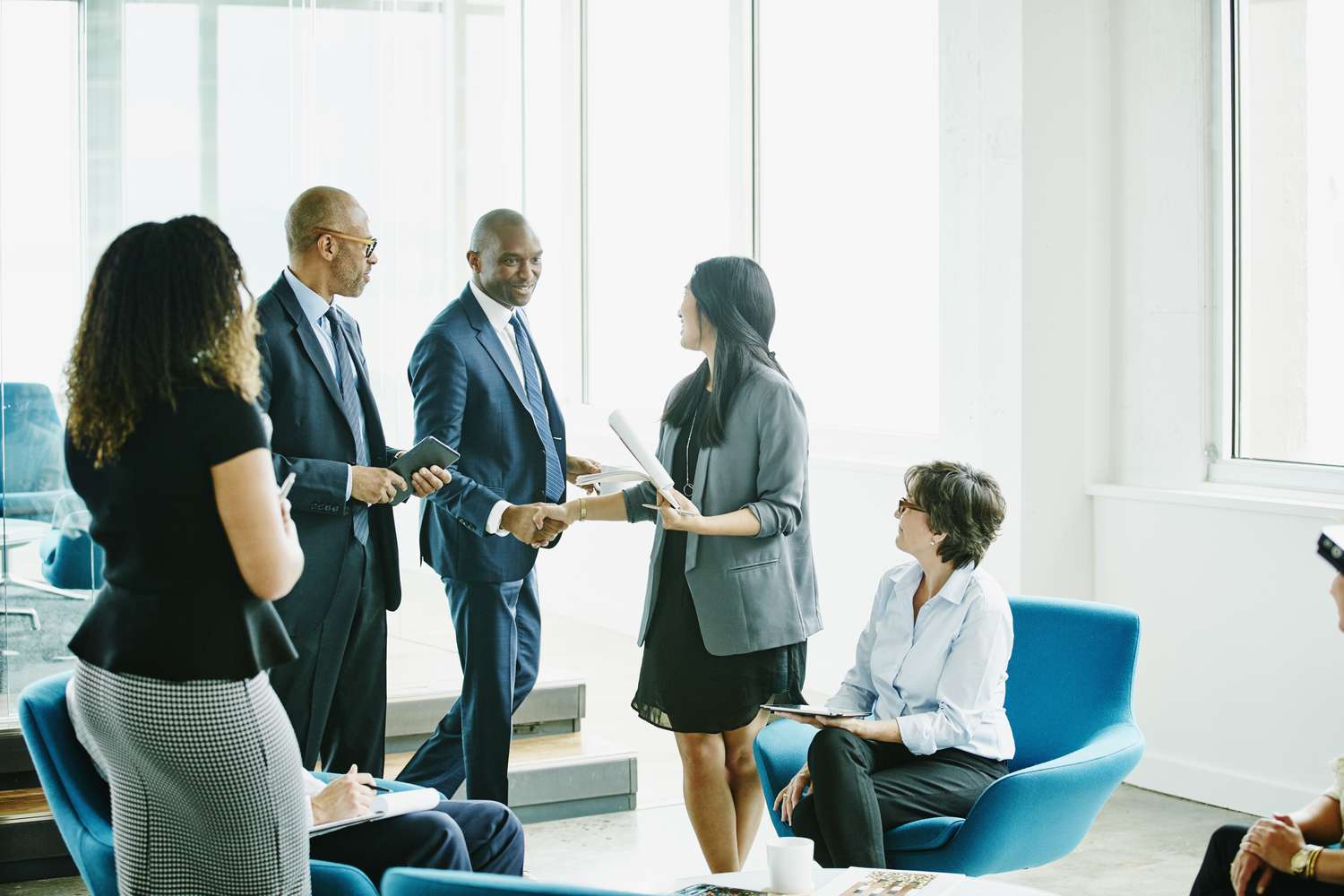 Smiling businessman shaking hands with colleague after meeting in office