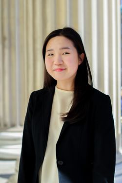 Erica Lee standing with cream background behind her