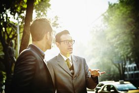 Two financial professionals talking outdoors