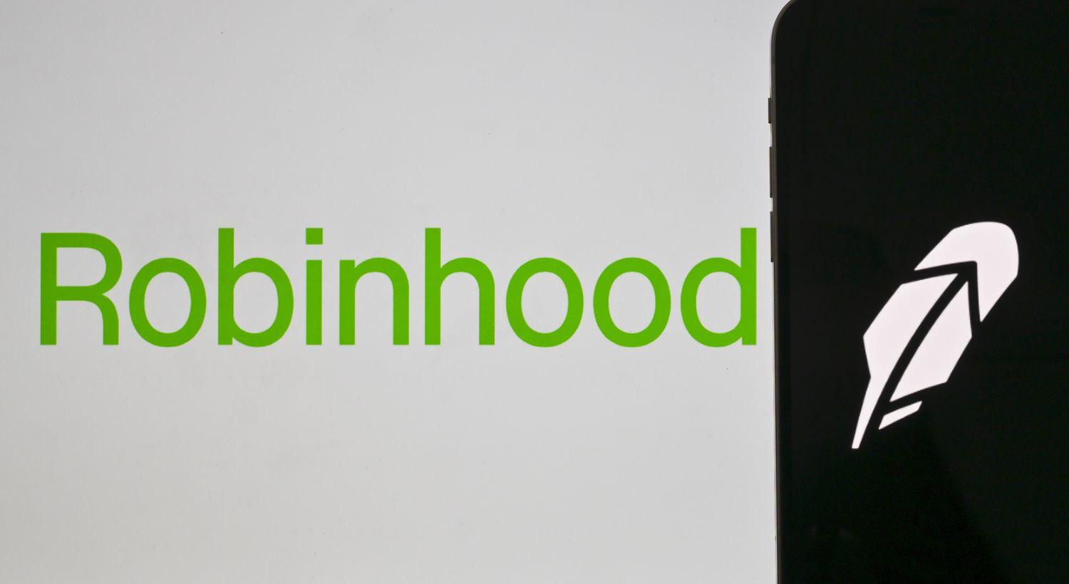 The word 'Robinhood' is displayed on a laptop screen and its logo on a phone screen in Ankara, Turkiye, on June 26, 2023