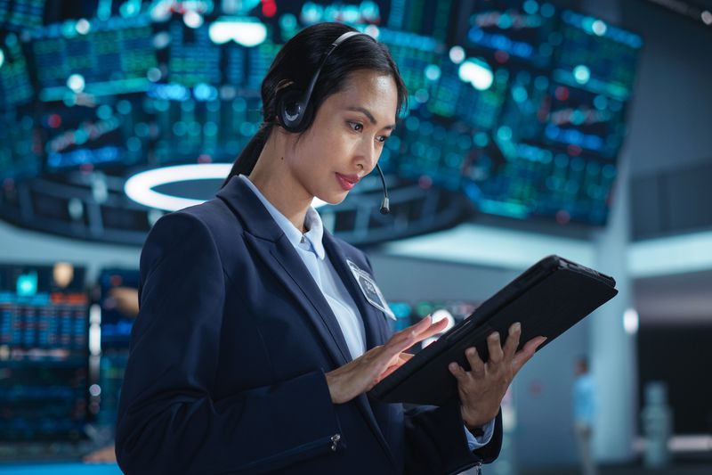 Female trader on the floor of an Exchange looking at a tablet
