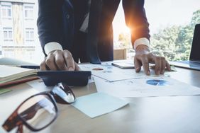 Close up Businessman using calculator for do math finance on wooden desk in office, tax, accounting, statistics and analytic research concept