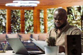 Financial analyst, working from home office, reviewing documents.