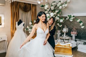 Beautiful young woman choosing a wedding dress in a modern wedding salon.