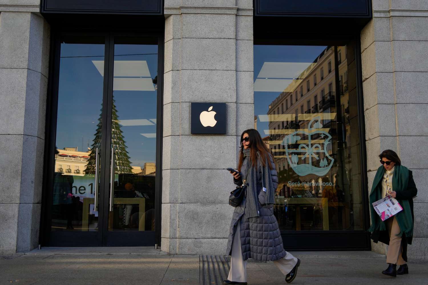 People walk past an Apple store in Madrid.