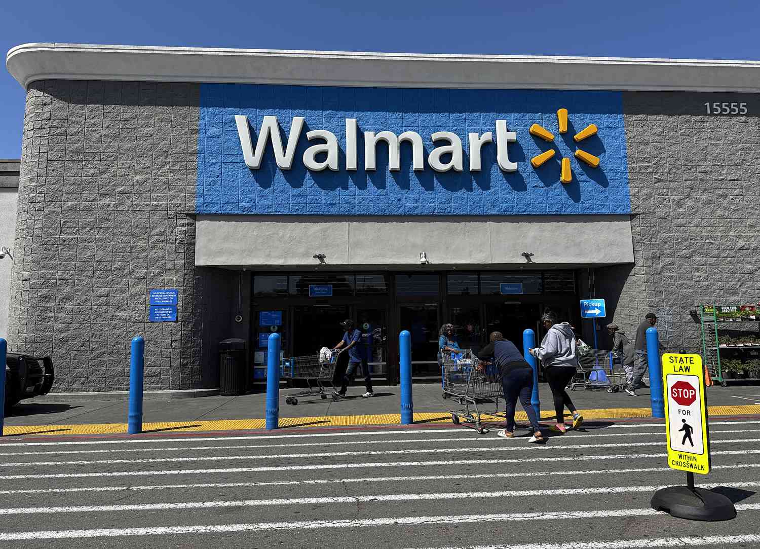 Customers enter a Walmart store on April 09, 2025 in San Leandro, California