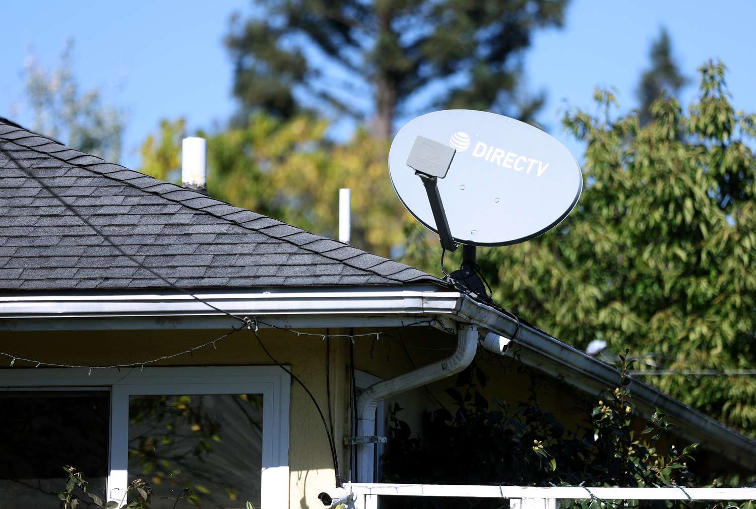 A DirecTV satellite dish is seen mounted to a building