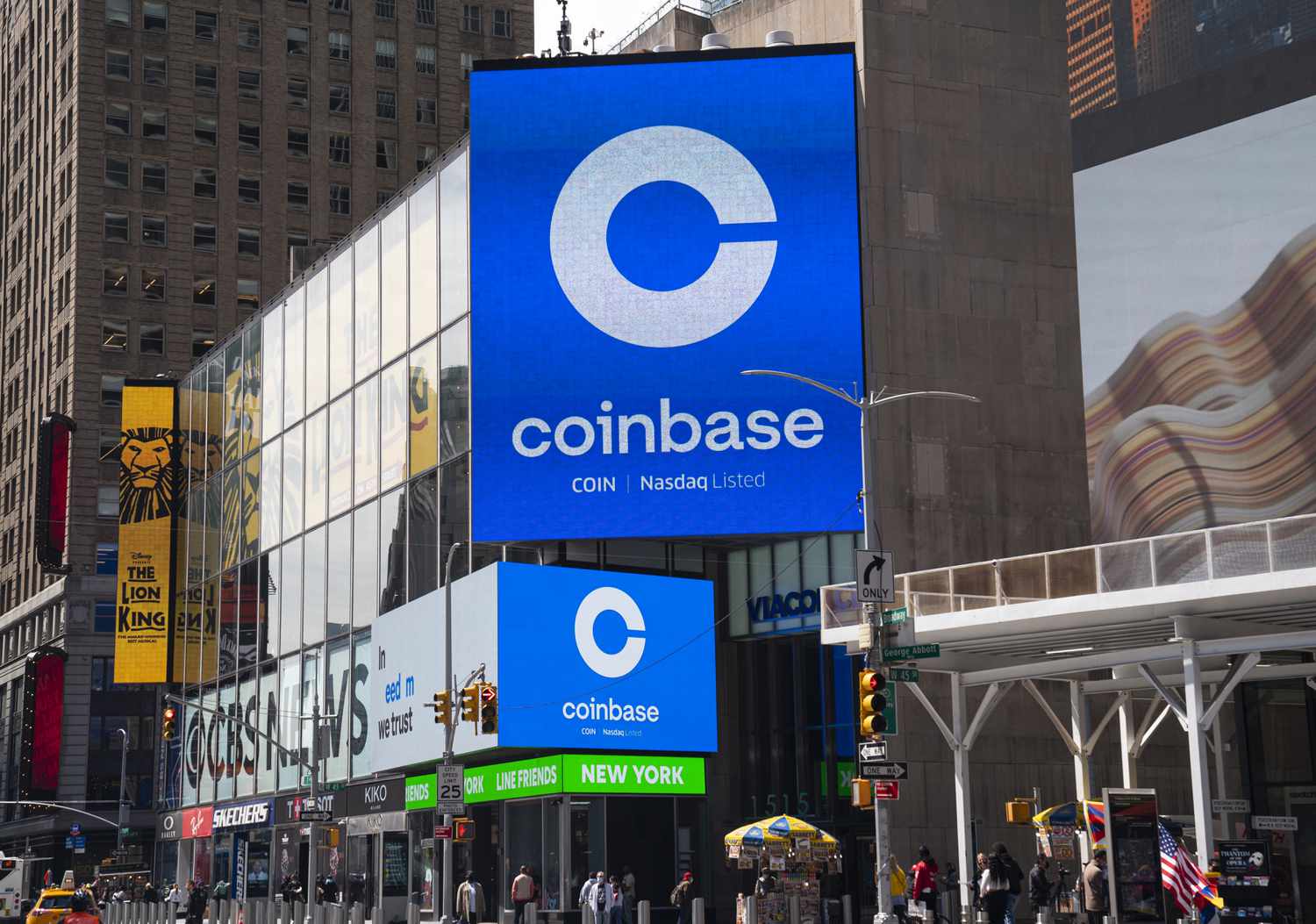 Coinbase billboard in an urban area with surrounding buildings and advertisements