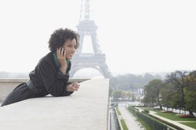 Woman outdoors on her mobile phone by the Eiffel Tower
