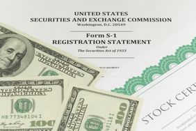 A closeup image of SEC Form S-1 Registration Statement, stock certificates, and hundred dollar bills.