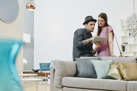 A couple uses a tablet to examine investment options. 