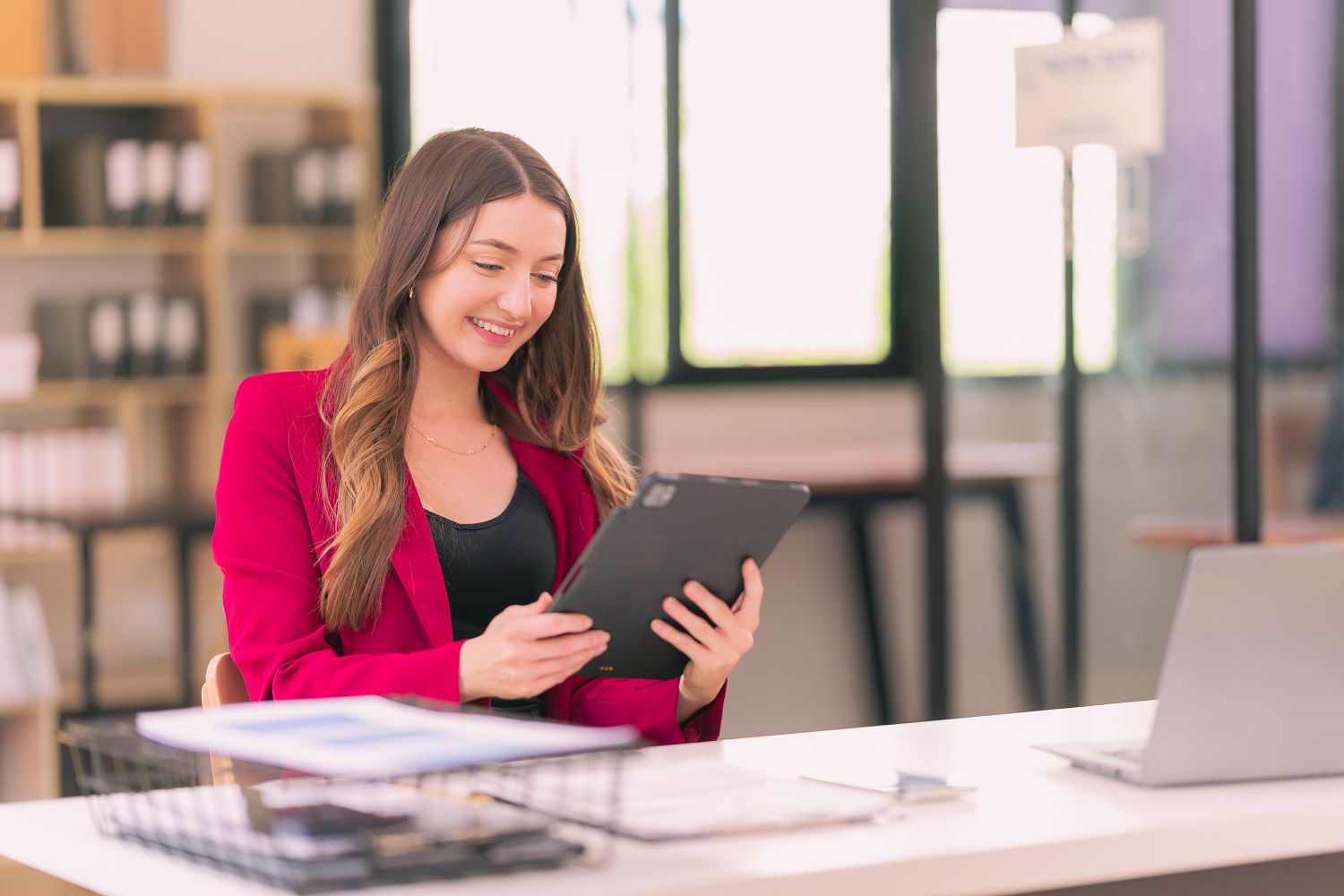 Young woman looking at a tablet and smiling.