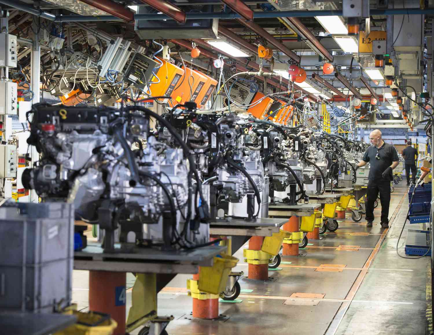 Worker on engine production line in a car factory