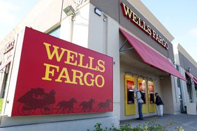 Customers use ATMs at a Wells Fargo Bank