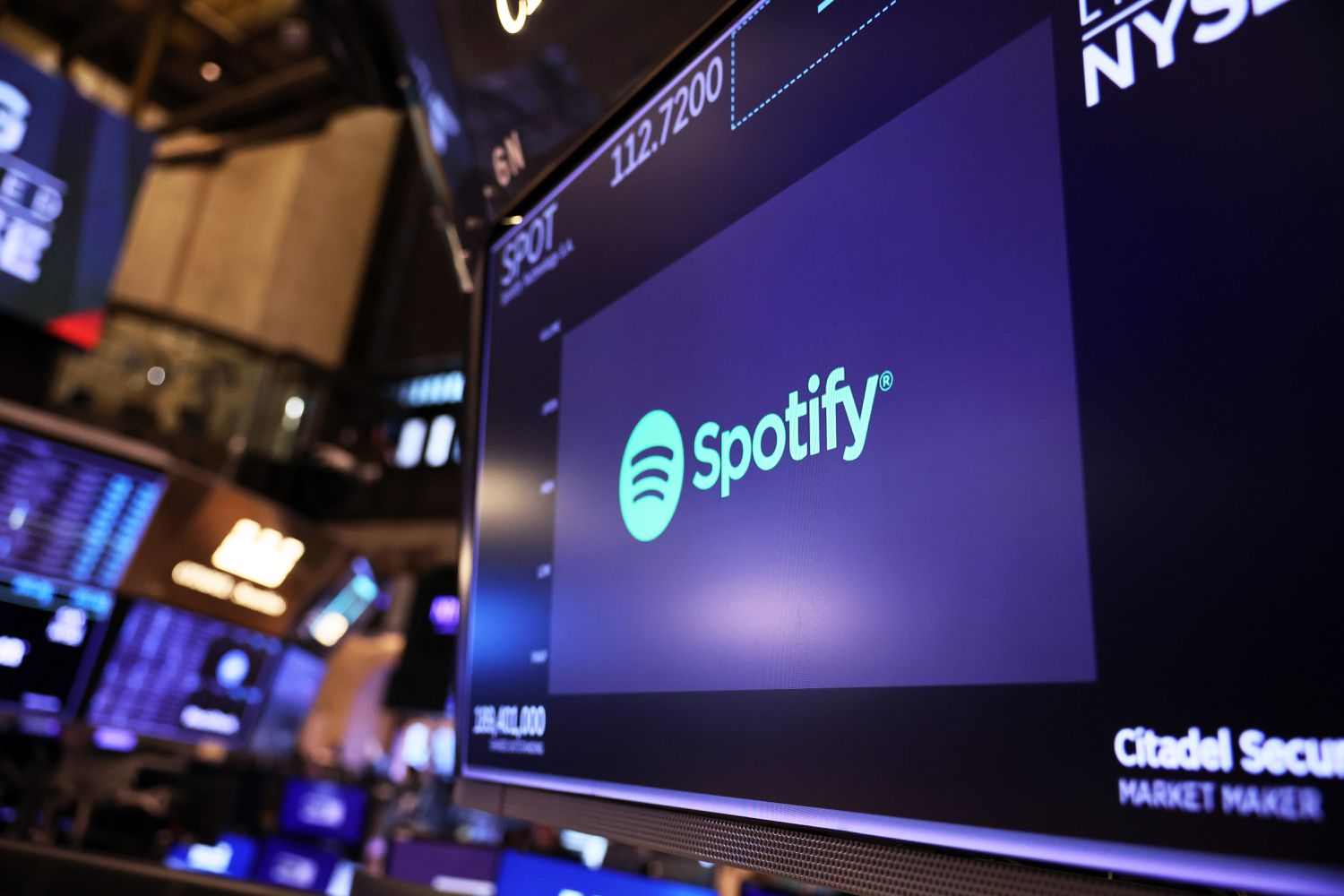 The Spotify company logo is displayed as traders work on the floor of the New York Stock Exchange