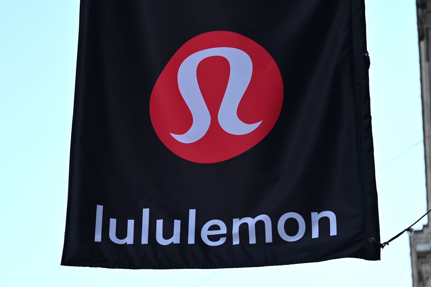 The red Lululemon logo is seen on a black banner outside a store.