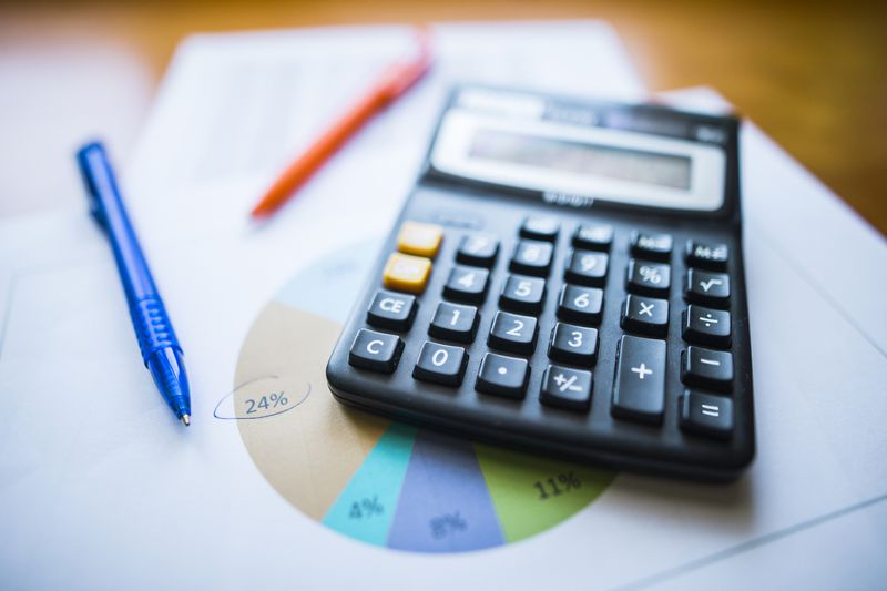 A Calculator and paper sheets with data.