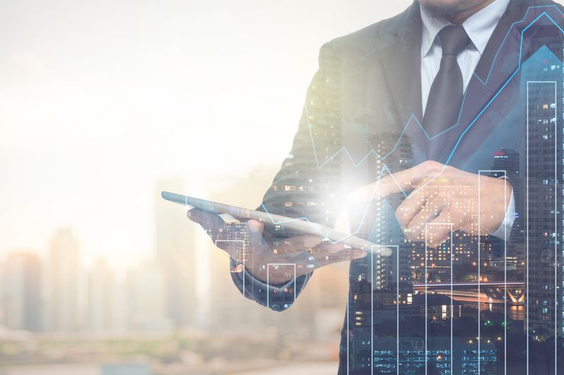 A man on a tablet surrounded by charts