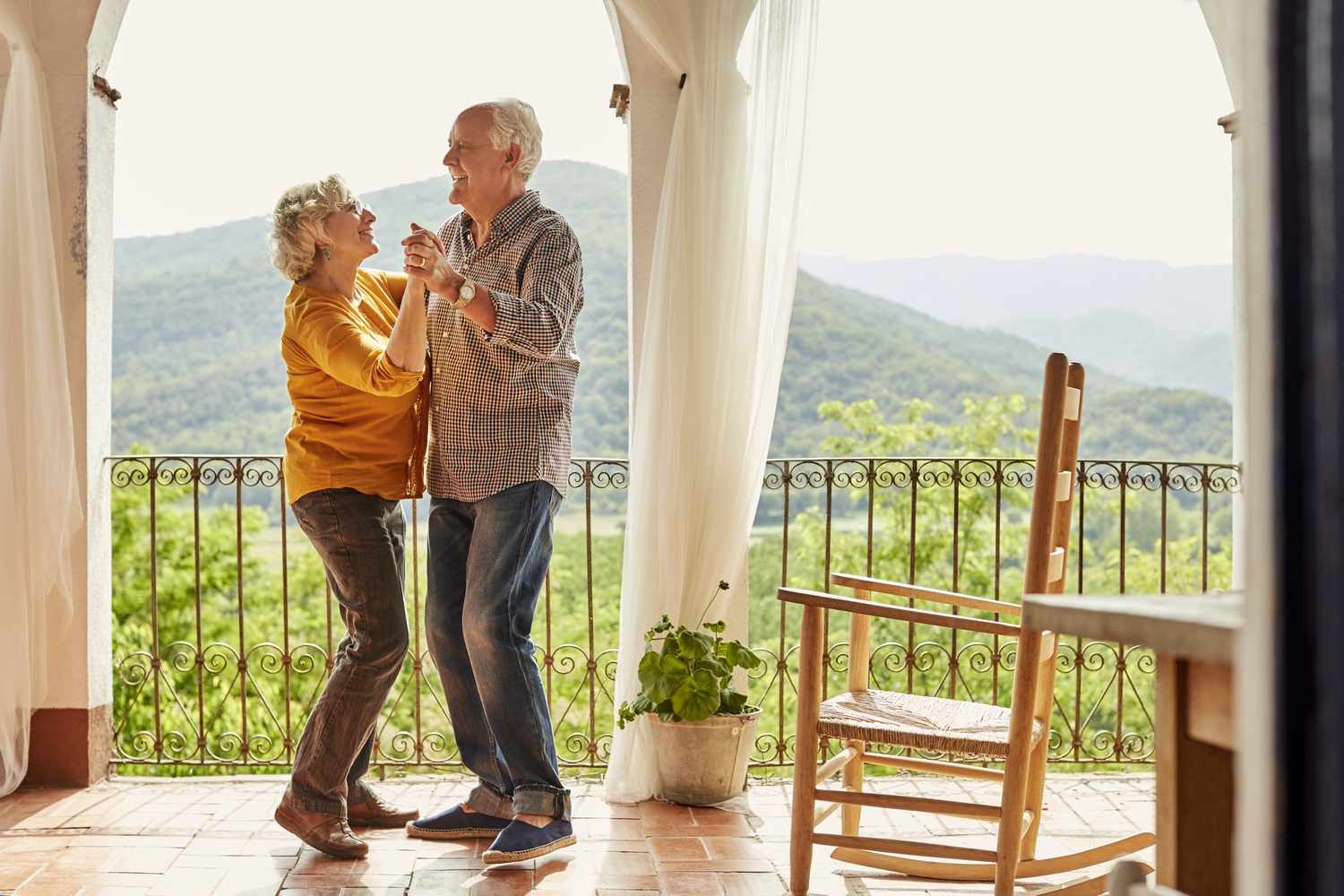Senior couple dancing on a balcony in Spain. 