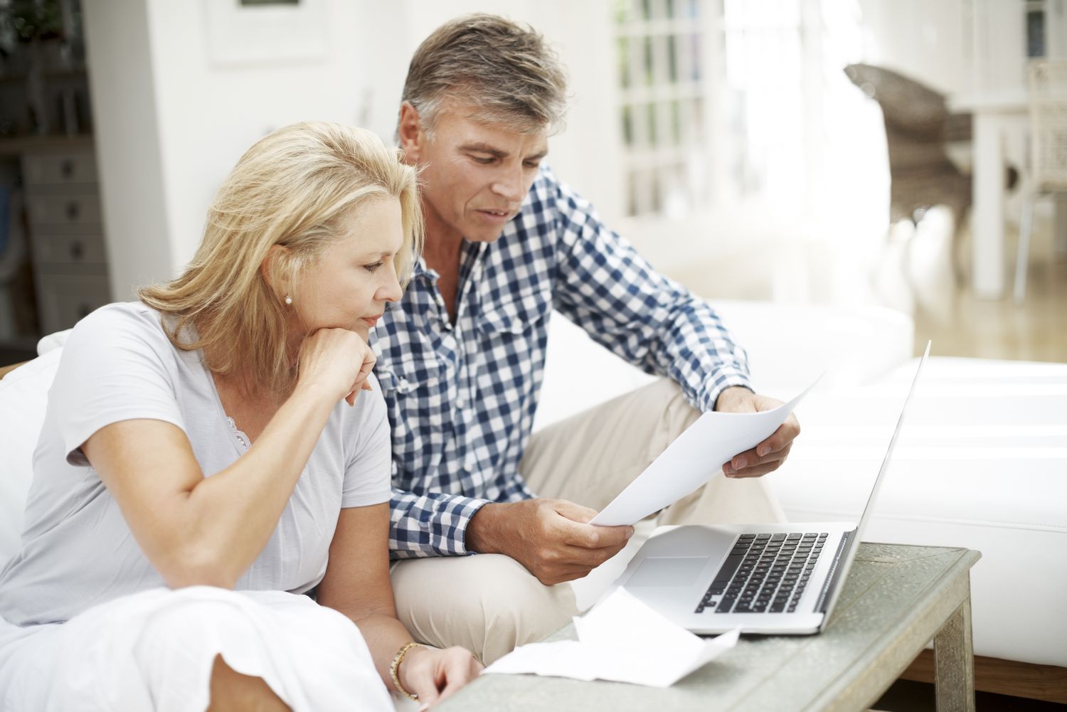 Mature couple doing paperwork and using computer