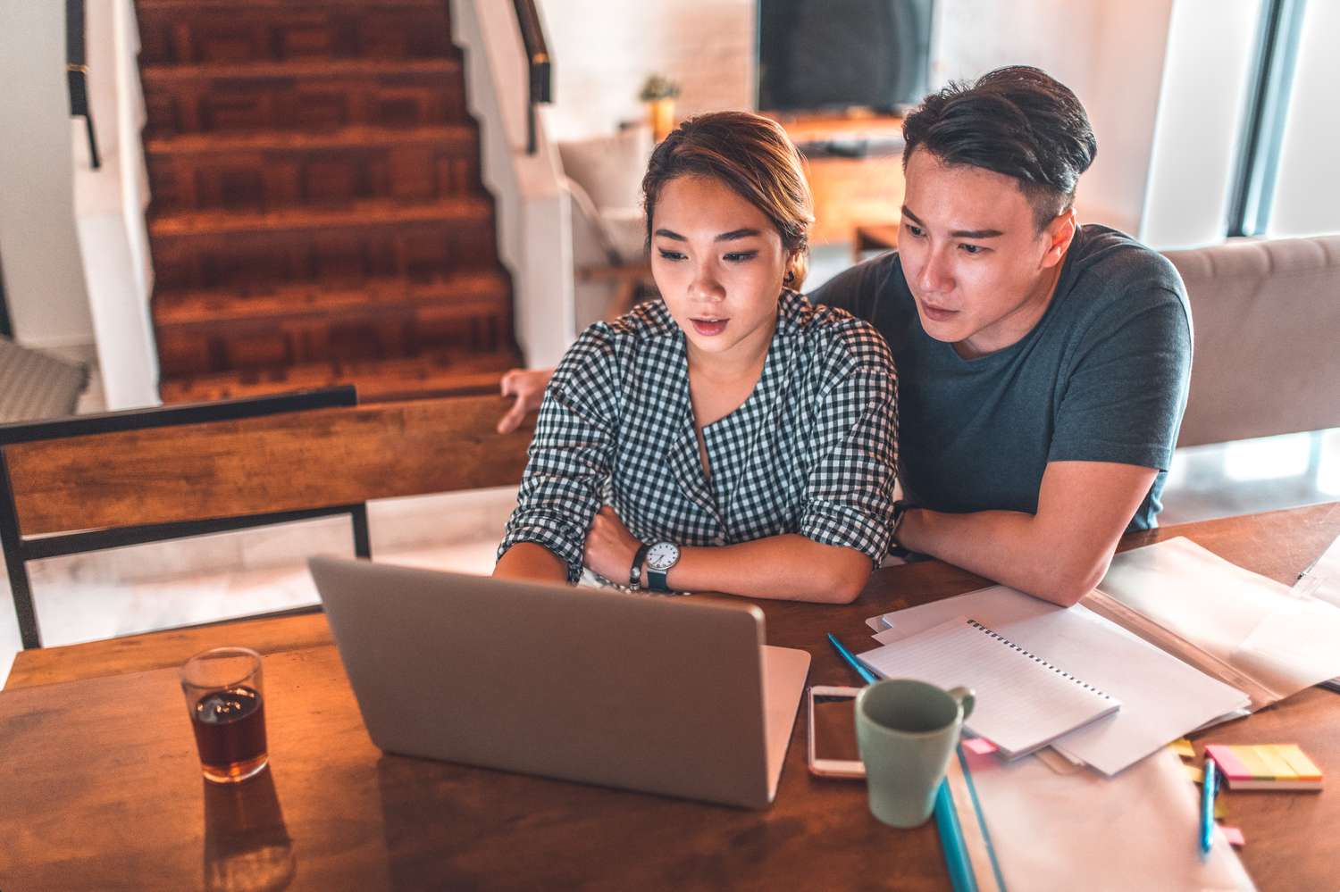 Young couple sitting at their dining room table and looking at online mortgage rates