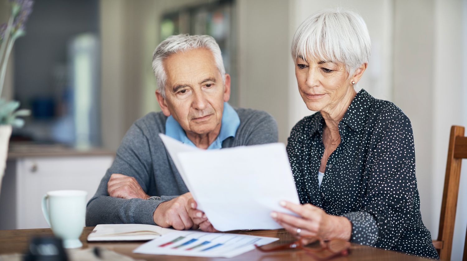 A couple going through their finances while sitting at the dining room table.