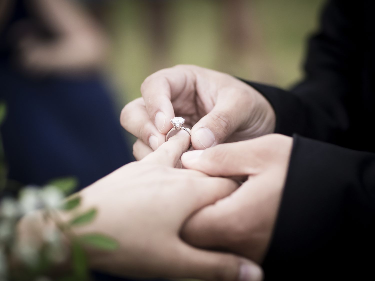 Wedding ceremony moment when the bride just placed the wedding ring on the groom's finger.
