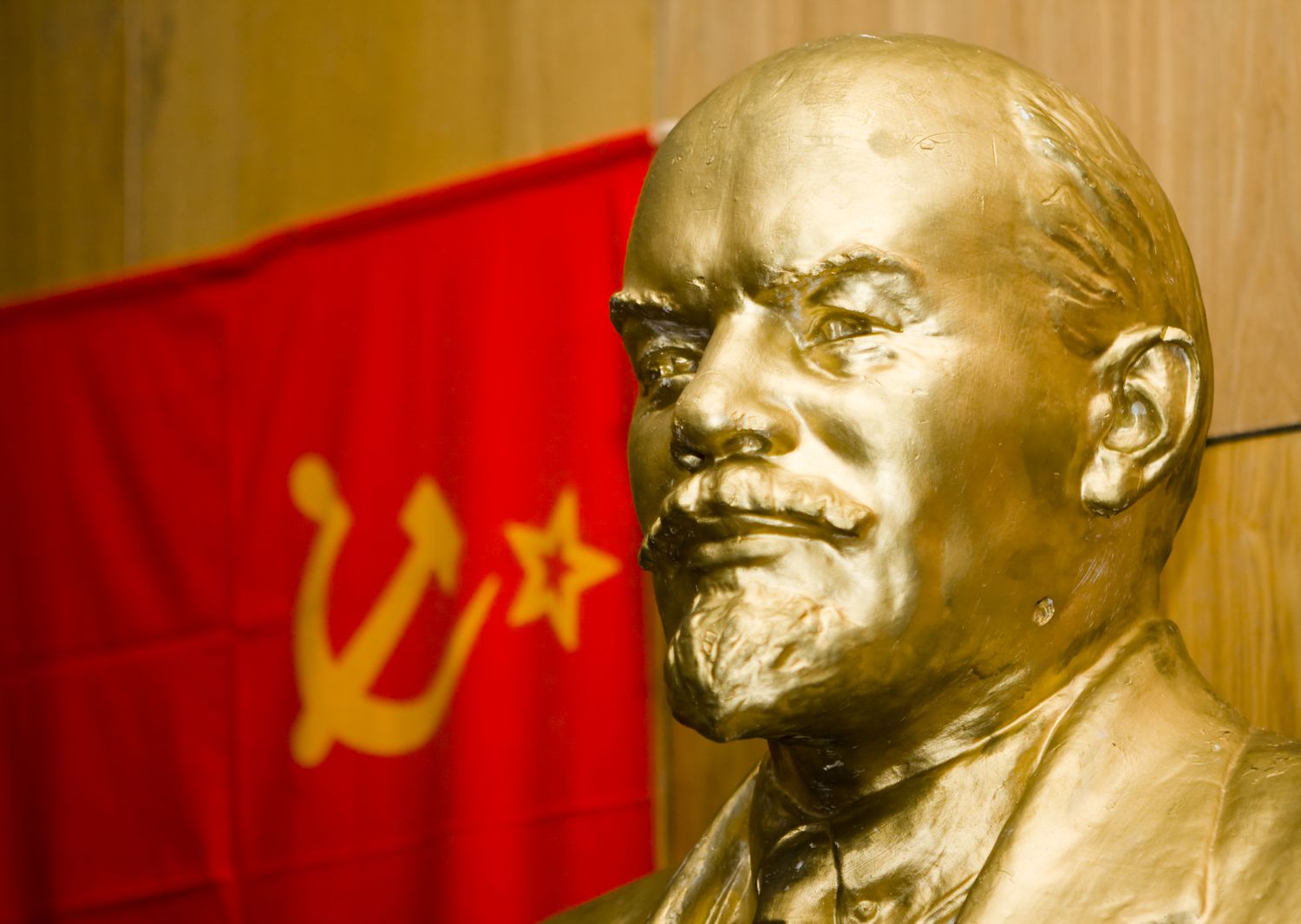 Bust of Vladimi Iljich Lenin in front of a flag for the USSR