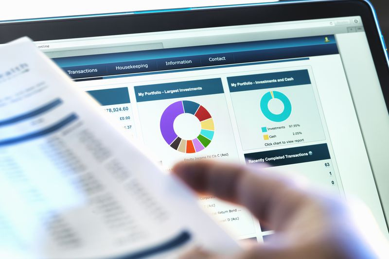 Cropped hand in front of a financial screen looking at financial data