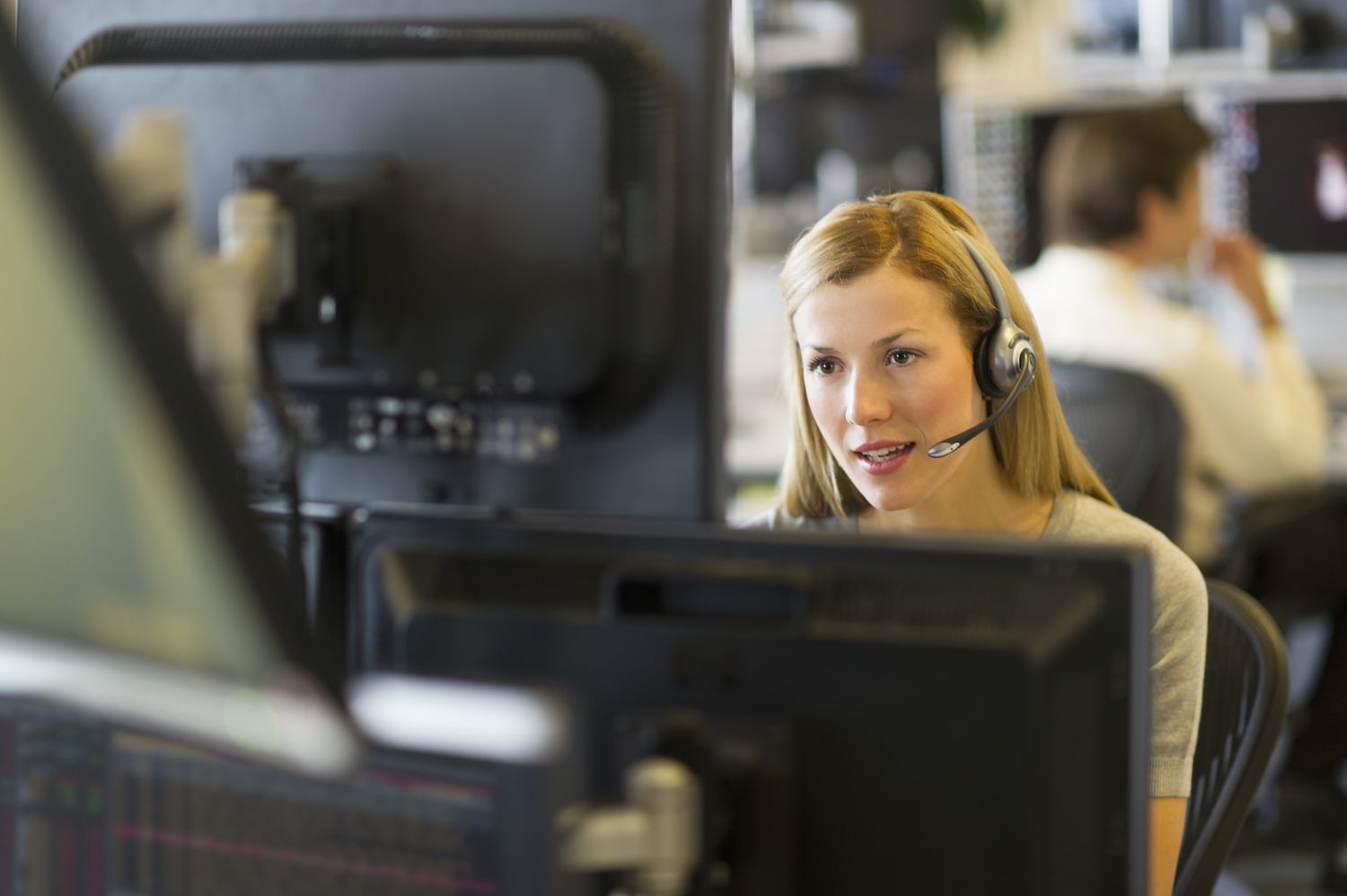 Stock market trader in front of screens