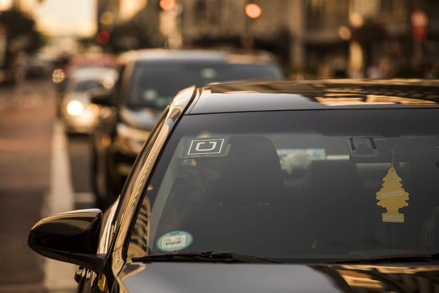 The Uber logo is seen on the windshield of a car in New York,