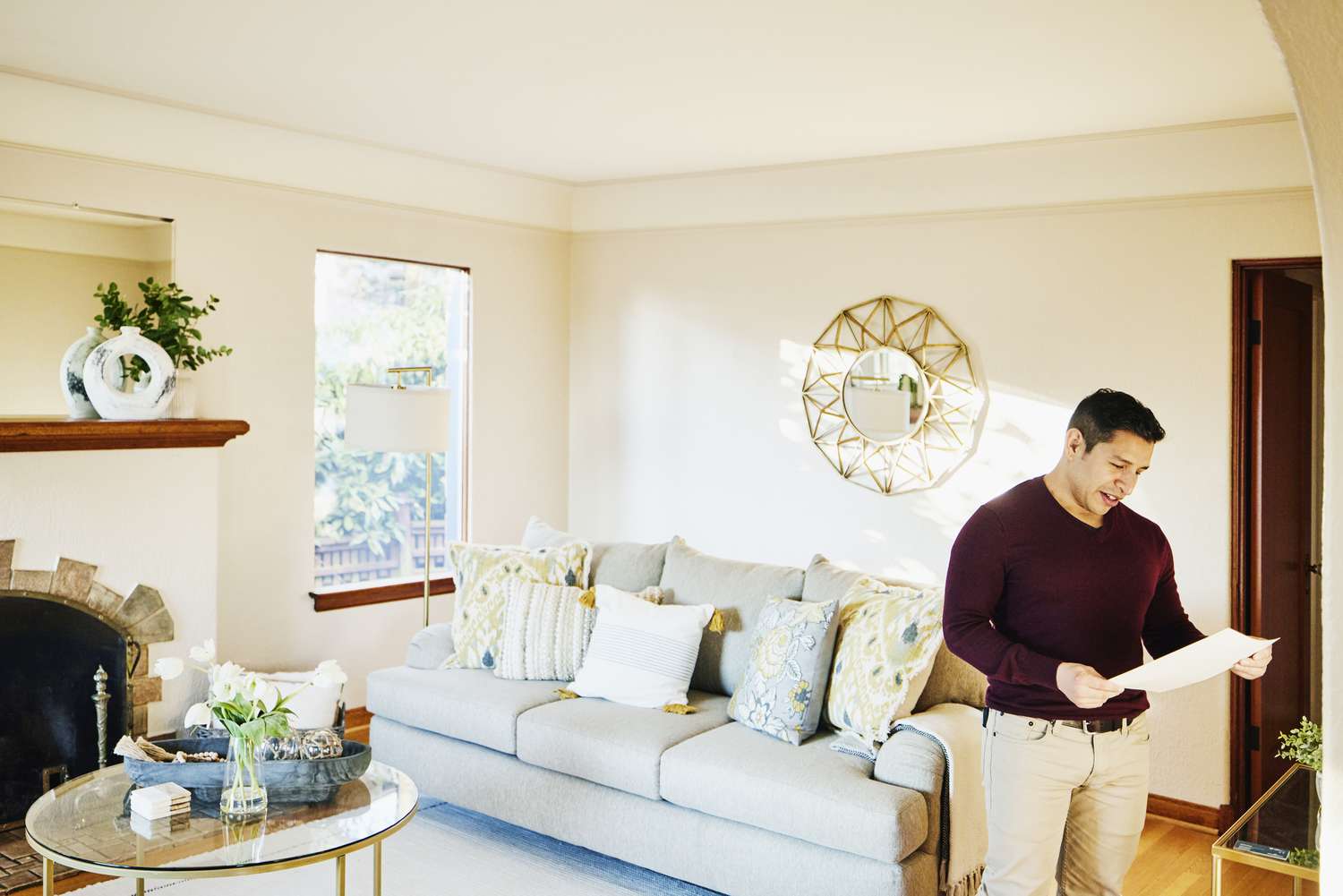Man looks at document while standing in his living room
