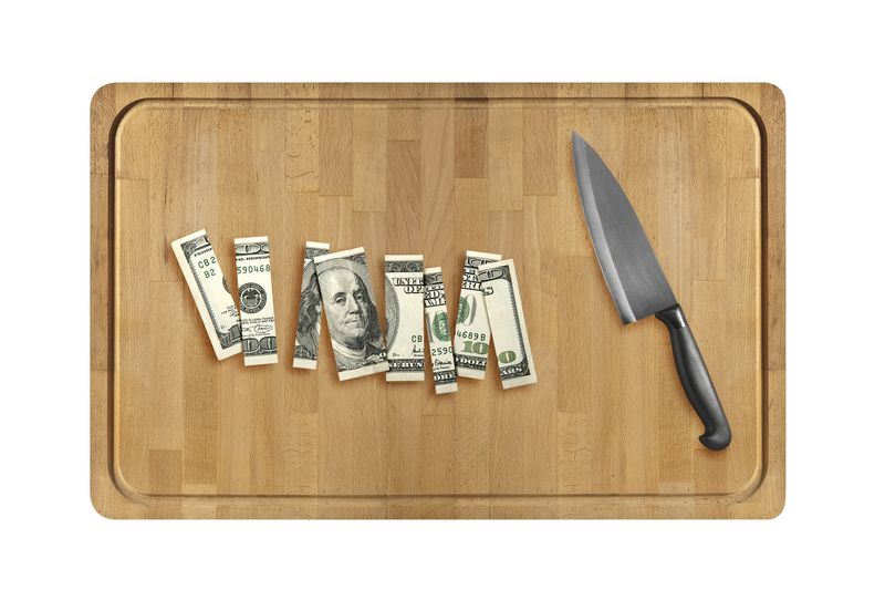 Knife and sliced hundred dollar on Wooden cutting board