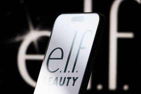 The logo of e.l.f. Beauty is displayed on a smartphone screen, with the company's sleek black-and-white branding visible in the background