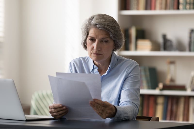 A serious business owner reads over the SEC Form 8-A before listing shares of their company on the stock exchange.