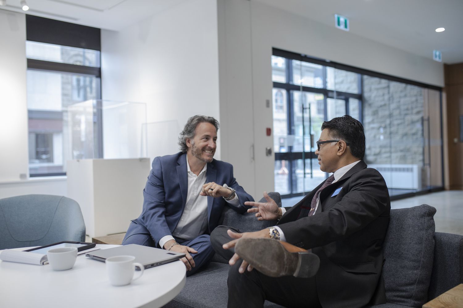 Smiling client talking with financial advisor in bank branch lobby about CD rates