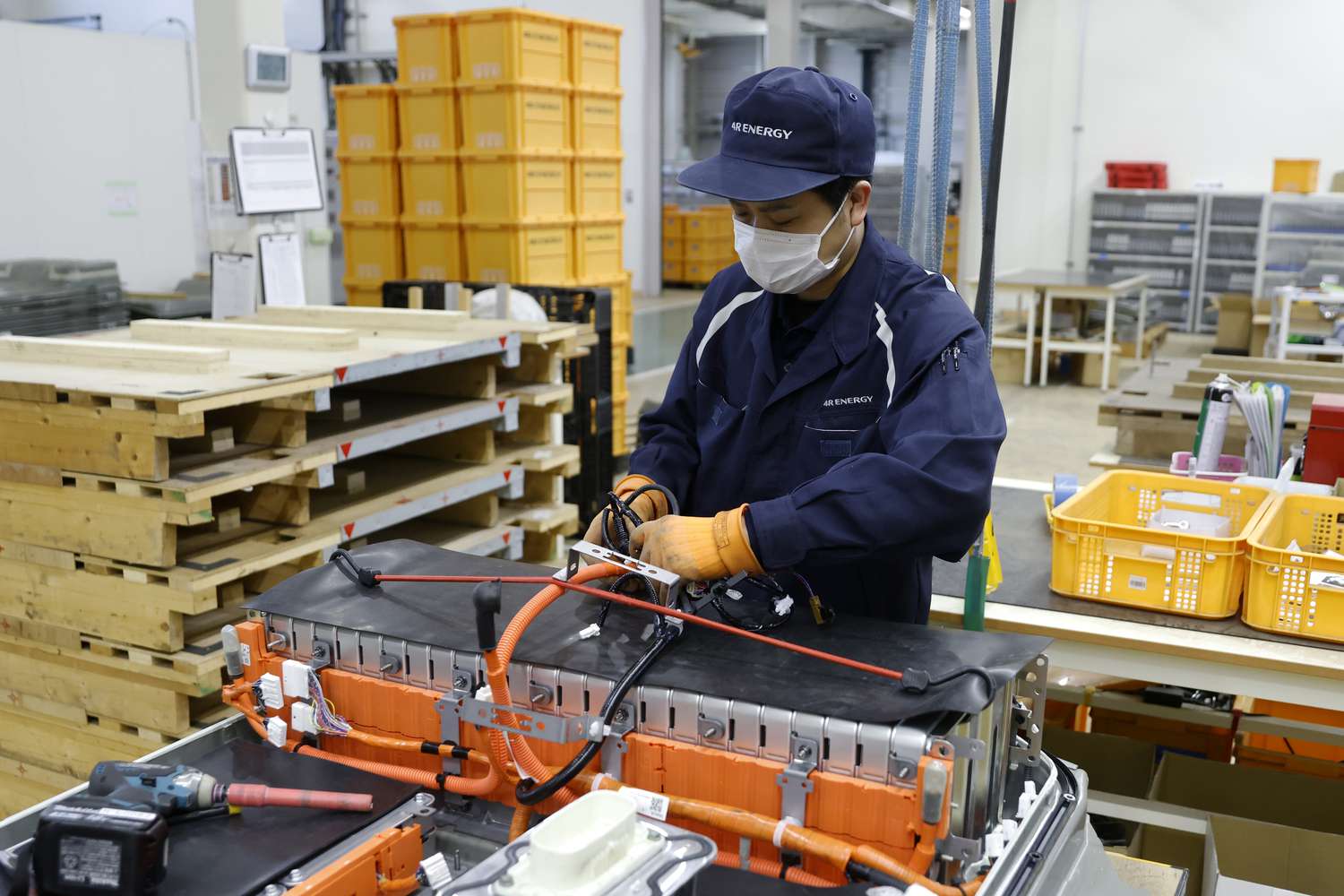 Worker disassembles a used lithium-ion EV battery