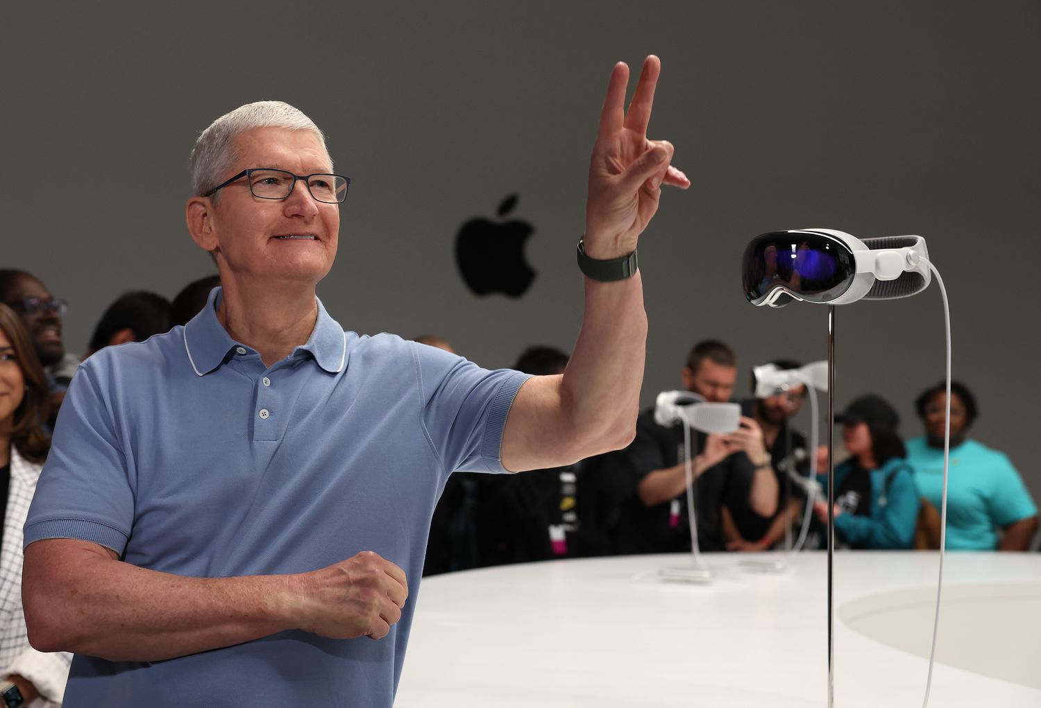 Apple CEO Tim Cook stands next to the new Apple Vision Pro headset is displayed during the 2023 Apple Worldwide Developers Conference 