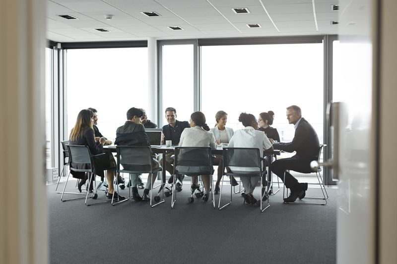 Co-workers having meeting with laptop in conference room