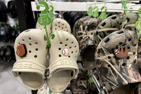 Tan and camo Crocs hang in a store