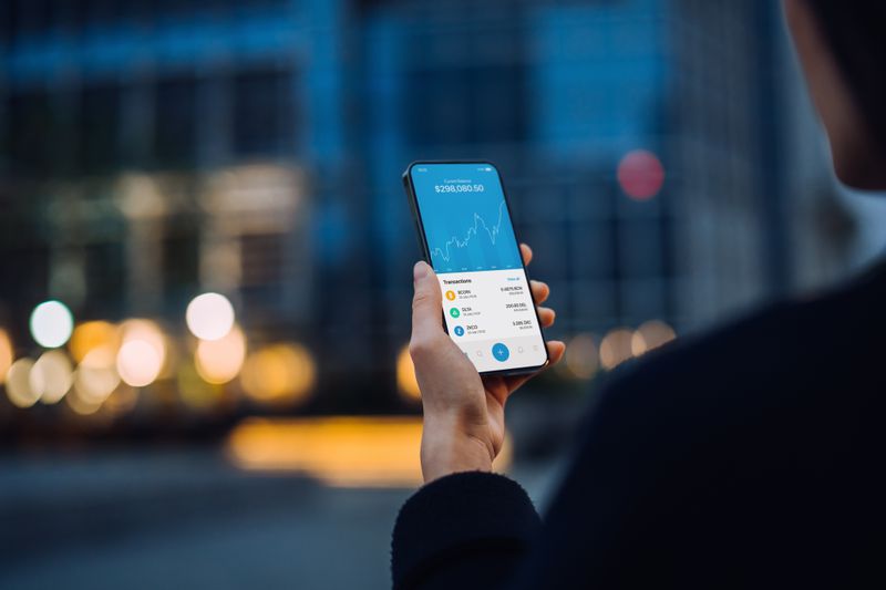 Person holding a mobile device looking at crypto currencies