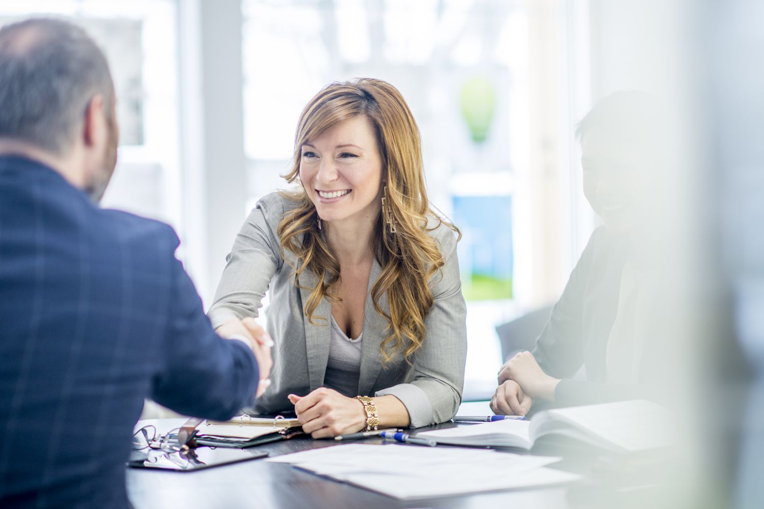 Realtor shakes hands with client after a house buying deal