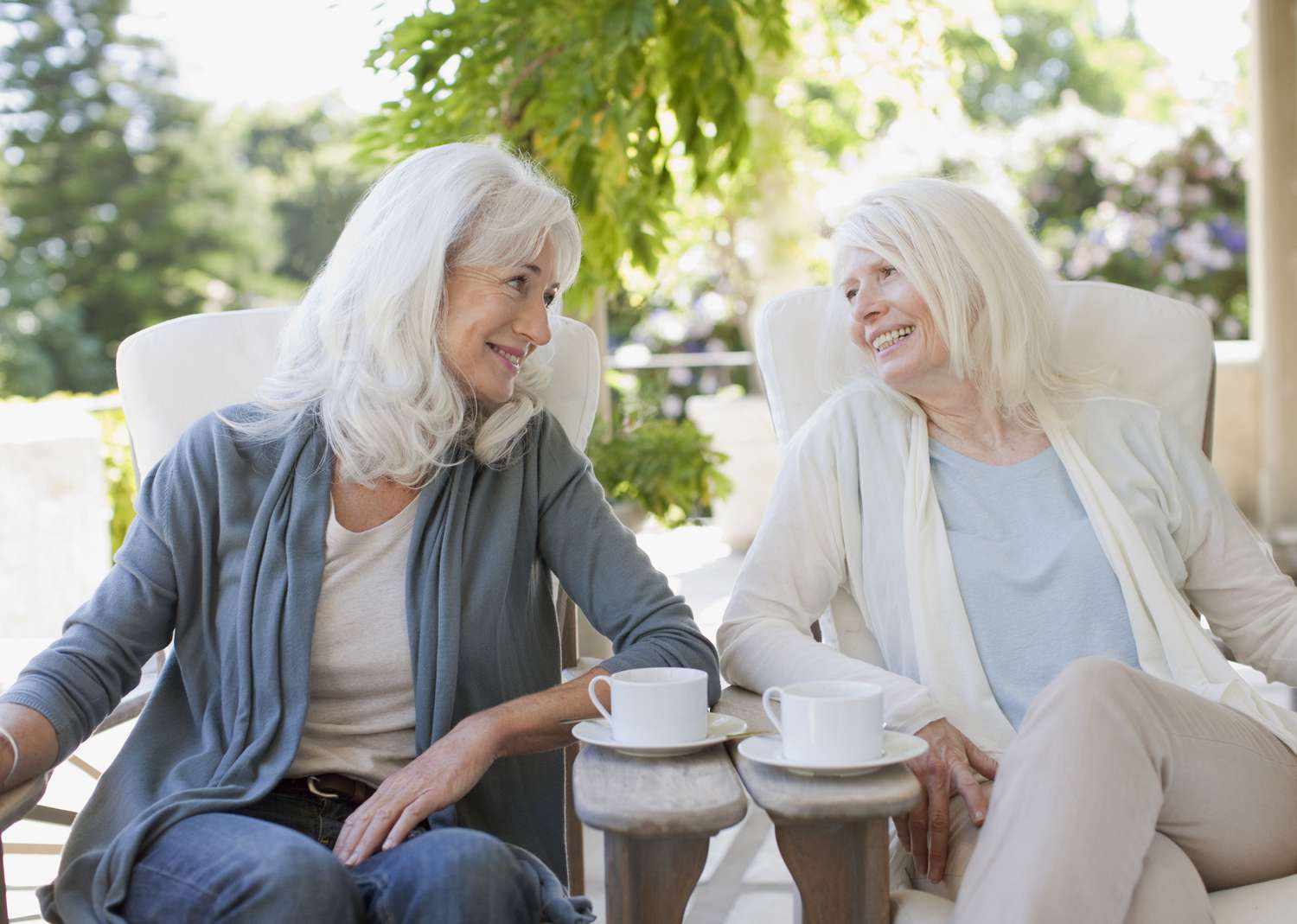 Friends sitting outside drinking coffee and talking about reverse mortgage age requirements.