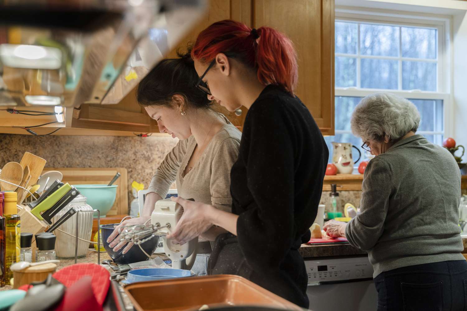 A crowded kitchen, women cooking and doing the dishes